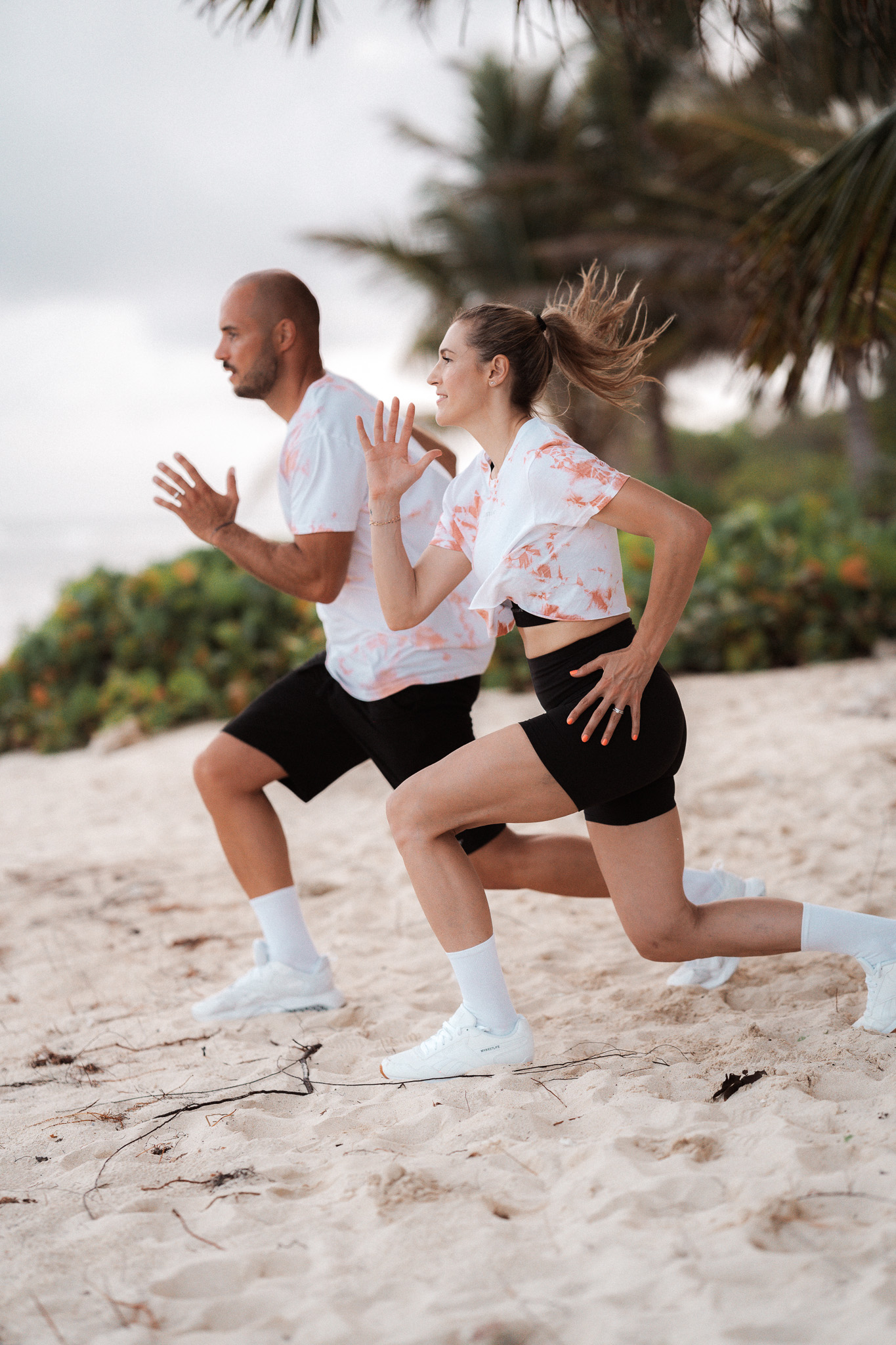 Une femme et un homme s'entraînent sur la plage.